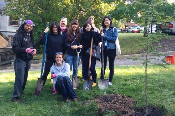 Photo of a group of Chatham University 学生 and staff members posing around a tree they planted